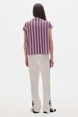 Blusa de rib a rayas verticales azules, rojas y blancas, de manga corta y cuello alto.