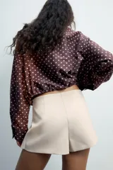 Falda pantalón de tiro medio color negro, con detalle de abertura en el delantero y cierre lateral con cremallera oculta.