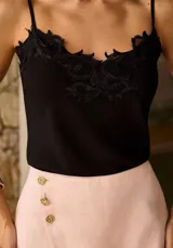 Musculosa celeste de tirantes finos con detalle de encaje bordado en el escote, silueta ligera y diseño romántico.