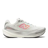 Championes de running New Balance 1080v15, color blanco con detalles en plateado y logo lateral con degradado en rosa y naranja. Presentan una mediasuela de gran volumen con tecnología Infinion para mayor amortiguación y retorno de energía, y una parte superior de malla transpirable.