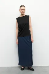 Top sin mangas color beige, de cuello redondo y corte ajustado. Presenta frunces en los laterales.