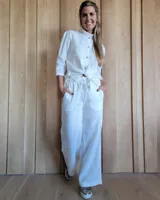 Pantalón de denim azul, de corte recto y tiro alto, con cintura elástica y cordón ajustable. Tiene bolsillos laterales.