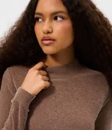 Blusa de manga larga confeccionada en tejido de chenille, con cuello alto y ajuste al cuerpo.