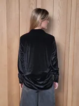 Camisa de jean de corte clásico, con cuello camisero, cierre frontal con botones y mangas largas con puños abotonados.