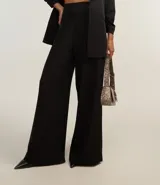 Pantalón pantalona femenina confeccionada en crepé, con cintura ancha, cremallera lateral y pences en la parte trasera.