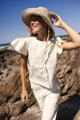 Blusa negra de lino con bordado en relieve de formas orgánicas, mangas cortas con volados y terminaciones desflecadas.