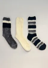 Pack de tres pares de medias de chenille de media caña. Un par gris con rayas negras y blancas, un par blanco liso y un par negro con rayas grises y blancas.
