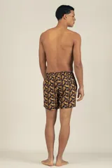 Short de baño con estampado floral en tonos marrones y amarillos, con cintura elástica ajustable con cordón.
