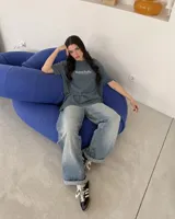 Remera oversize negra con diseño gráfico en la espalda que incluye la inscripción "Kaboa Radio" y un personaje ilustrado, de corte amplio y mangas cortas.