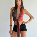 Top halter de tela brillante con efecto degradado que va del negro al naranja rojizo, anudado al frente.