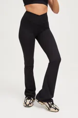 Calza larga negra de compresión media con cintura cruzada y corte acampanado.