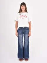 Jean de tiro alto con corte wide leg, confeccionado en denim azul con efecto lavado y costuras en contraste. Presenta diseño de cinco bolsillos y ruedo con doble costura.
