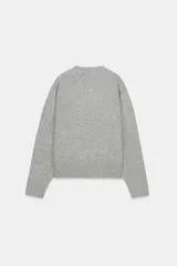 Jersey de punto color vino tinto, de cuello redondo y manga larga, con acabado acanalado (rib) en puños, cuello y bajo.