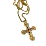 Collar dorado con dije de cruz con incrustaciones de circonitas de colores.