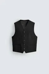 Chaleco de traje regular fit con cuello en pico y cierre frontal de botonadura. Presenta bolsillos de vivo en la parte delantera, detalle de bolsillo interior y cintura ajustable en los laterales con trabillas.