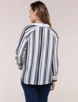 Camisa de crepe blanca con rayas verticales negras, cuello camisero, mangas largas raglán y cierre frontal con botones.