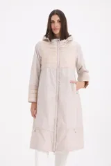 Pilotín largo con capucha, diseño combinado con secciones en matelassé en el pecho, mangas y ruedo. Cuenta con cierre frontal, bolsillos laterales y cordones ajustables en la capucha.