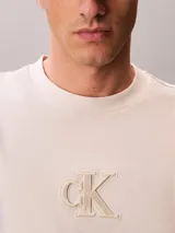 Remera de manga corta Calvin Klein color beige, de corte regular y cuello redondo, con el monograma de la marca estampado en el pecho.