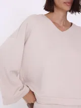 Sweater color visón con escote en V y corte asimétrico.