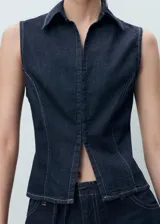 Top sin mangas estilo chaleco confeccionado en tejido de algodón y lino, con cuello solapa, cierre frontal con cremallera y costuras en contraste.