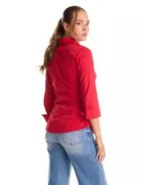 Camisa entallada de color rojo, con cuello solapa, escote en V y cierre frontal con botones. Presenta una pechera con alforzas horizontales y mangas tres cuartos con puños anchos rebatibles.