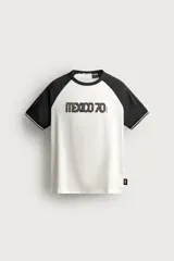 Camiseta regular fit de manga corta raglán en color blanco y negro, con cuello redondo y el estampado 'Mexico 70' en el frente.