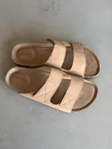 Sandalias planas color camel con doble tira ancha con costuras a la vista y plantilla de corcho.