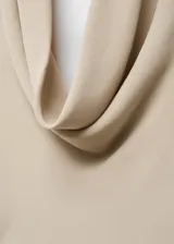 Vestido largo color beige con escote halter drapeado y espalda descubierta.