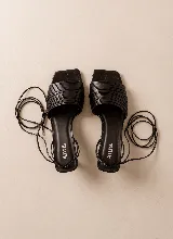 Sandalia de cuero tostado con múltiples tiras finas en la parte delantera, punta cuadrada y taco medio de diseño acampanado. Cuenta con cordones largos para atar alrededor del tobillo.