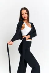 Top deportivo negro de manga larga con diseño envolvente y tiras largas para anudar en la cintura.