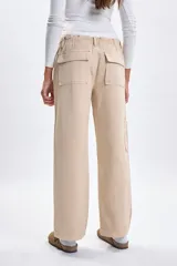 Pantalon tipo cargo de jean en color beige, con corte recto y bolsillos laterales funcionales.