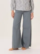 Pantalón ancho de algodón color verde oliva, con corte holgado desde la cadera hasta el tobillo. Presenta pinzas debajo de la rodilla, bordado de monograma en el bolsillo delantero y pespuntes a contratono.