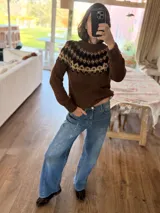 Sweater tejido a mano con diseño de guarda nórdica en la parte superior, en tonos marrones, beige y negro. Presenta cuello redondo, mangas largas y puños acanalados.