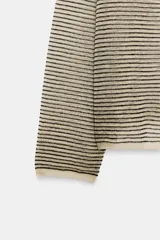 Sweater de punto fino color beige con finas rayas horizontales negras, cuello redondo y manga larga.