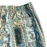 Short de baño con estampado ornamental de estilo paisley y rayas verticales en tonos azules, verdes y blancos. Cuenta con cintura elástica, dos bolsillos laterales y un bolsillo trasero.
