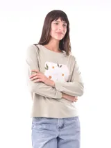 Remera de manga larga color azul, con cuello redondo y un estampado central de flores en tonos pastel sobre un recuadro gris claro.