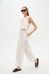 Musculosa de algodón color celeste, con cuello redondo y detalles bordados en tono blanco con diseño de broderie en la parte frontal. Cuenta con cordones laterales para ajustar.