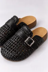 Zuecos cerrados de punta redondeada color negro, con empeine de material trenzado, tira superior con hebilla metálica ajustable y plantilla anatómica color tostado.