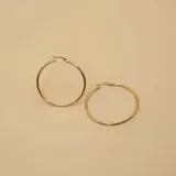 Aros tipo argolla de oro 18k con diseño torneado y acabado brillante.