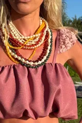 Conjunto de dos piezas compuesto por un top corto con volados en los hombros y una falda larga con múltiples niveles de volados, ambos con ajuste elástico.