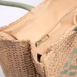 Bolso tipo tote de yute color marrón claro, con diseño geométrico verde en el centro y doble asa de mano verde.