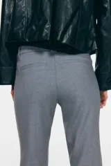 Pantalón sastrero gris de tiro alto, corte ajustado y piernas acampanadas, con trabillas para cinto y bolsillos traseros insertados.