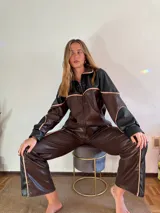 Pantalón de cuero sintético marrón con detalles en negro y vivos color crema.