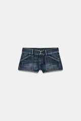 Shorts mini de denim tiro bajo, con bolsillos de plastrón delanteros y traseros, trabillas para cinto y cierre frontal con cremallera y doble botón metálico.