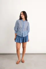 Camisa de algodón bordado color celeste, con cuello mao, mangas 3/4 abullonadas y cierre frontal con broches tipo orientales.