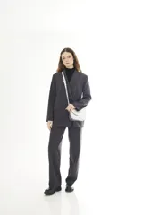 Bandolera compacta de cuero vacuno color gris con efecto gastado, solapa redondeada y correa ajustable.