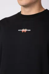 Remera negra de corte regular, manga corta y cuello redondo, con pequeño estampado frontal centrado con el texto 'VCP COLLECTION' y diseño de cerezas.