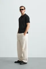 Polo de manga corta color verde oliva, con cuello solapa y abertura frontal tipo polo. Presenta una textura acanalada vertical y un calce regular.