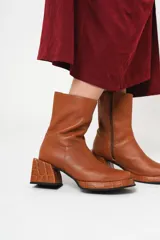 Bota de cuero color marrón con caña media, plataforma delantera de 2 cm y taco cuadrado de 7 cm.