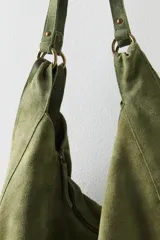 Bolso tote de ante suave, de cuerpo blando estilo hobo, con asa larga para el hombro y cierre superior con cremallera.